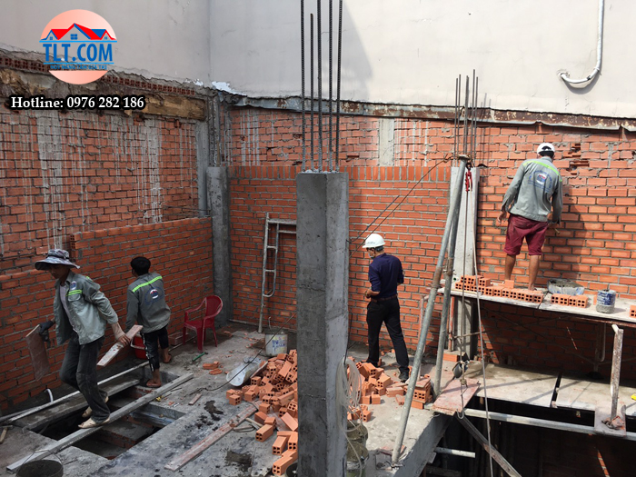 Đội ngũ thợ đang tiến h&agrave;nh x&acirc;y tường bao v&agrave; kỹ sư gi&aacute;m s&aacute;t kiểm tra chất lượng